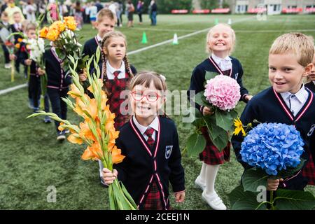 (200901) -- VILNIUS, 1. September 2020 (Xinhua) -- die Schüler nehmen am 1. September 2020 an der Eröffnungsfeier mit Blumensträußen in der Hand Teil, die den Beginn eines neuen Schuljahres am Gymnasium Vilnius Fabijoniskiu in Vilnius, Litauen, markiert. Litauens neues Schuljahr hat normal begonnen, aber Fernunterricht könnte in bestimmten Schulen wieder aufgenommen werden, wenn sie zu COVID-19 Hotspots werden. (Foto von Alfredas Pliadis/Xinhua) Stockfoto