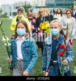 (200901) -- VILNIUS, 1. September 2020 (Xinhua) -- die Schüler nehmen am 1. September 2020 an der Eröffnungsfeier mit Blumensträußen in der Hand Teil, die den Beginn eines neuen Schuljahres am Gymnasium Vilnius Fabijoniskiu in Vilnius, Litauen, markiert. Litauens neues Schuljahr hat normal begonnen, aber Fernunterricht könnte in bestimmten Schulen wieder aufgenommen werden, wenn sie zu COVID-19 Hotspots werden. (Foto von Alfredas Pliadis/Xinhua) Stockfoto