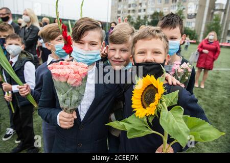 (200901) -- VILNIUS, 1. September 2020 (Xinhua) -- die Schüler nehmen am 1. September 2020 an der Eröffnungsfeier mit Blumensträußen in der Hand Teil, die den Beginn eines neuen Schuljahres am Gymnasium Vilnius Fabijoniskiu in Vilnius, Litauen, markiert. Litauens neues Schuljahr hat normal begonnen, aber Fernunterricht könnte in bestimmten Schulen wieder aufgenommen werden, wenn sie zu COVID-19 Hotspots werden. (Foto von Alfredas Pliadis/Xinhua) Stockfoto