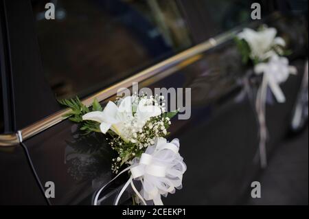 Schwarzer Körper Auto mit Blumen und Bögen Dekorationen für die Hochzeit. Stockfoto