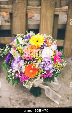 Haufen von verschiedenen bunten Blumen auf dem Tisch und sportliches Fahrrad im Innenbereich. Stockfoto