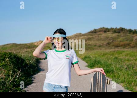 Stilvolle Teenager-Mädchen mit langen Bord im Sommer Stockfoto