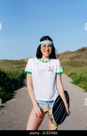 Stilvolle Teenager-Mädchen mit langen Bord im Sommer Stockfoto