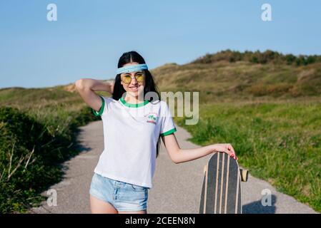 Stilvolle Teenager-Mädchen mit langen Bord im Sommer Stockfoto