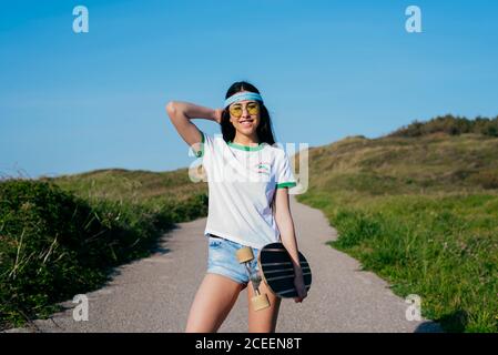 Stilvolle Teenager-Mädchen mit langen Bord im Sommer Stockfoto
