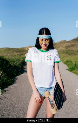 Stilvolle Teenager-Mädchen mit langen Bord im Sommer Stockfoto