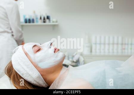 Kosmetologe Anwendung Maske auf das Gesicht des Kunden im Spa-Salon. Wellness-Center. Beruf im Gesundheitswesen Stockfoto