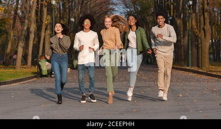 Verrückte Teens laufen in Richtung Kamera, Park Hintergrund Stockfoto