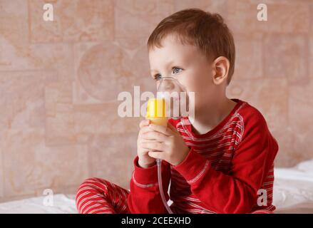 Krankes Kind macht sich Inhalationsmaske zum Atmen zu Hause Stockfoto