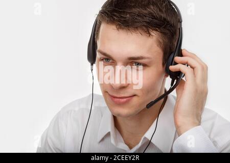 Nahaufnahme Porträt eines männlichen Kundendienstmitarbeiters oder Callcenter-Mitarbeiters oder Bedieners oder Support-Personals, das mit einem Kopfsatz spricht, isoliert auf Weiß Stockfoto