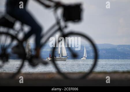 Langenargen, Deutschland. September 2020. Mehrere Boote fahren vor Langenargen am Bodensee, während im Vordergrund ein Radfahrer vorbeifährt. Quelle: Felix Kästle/dpa/Alamy Live News Stockfoto