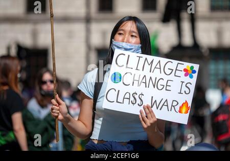 London, Großbritannien. September 2020. Extinction Rebellion Demonstranten versammeln sich vor den Häusern des parlaments. Ein junger Rebell hält ein Zeichen mit der Aufschrift ‘Klimawandel ist Klassenkrieg’ hoch. Frustriert über das Versagen der Regierung, auf die Klima- und ökologische Notlage zu reagieren, protestiert XR weiterhin für den Wandel. Der Climate and Ecological Emergency Bill (CEE Bill) ist der einzige konkrete Plan, der zur Verfügung steht, um diese Krise zu bewältigen, und so fordert XR an ihrem ersten Tag im Parlament die Regierung, jetzt zu handeln und diese Gesetzgebung anzunehmen. Quelle: Neil Atkinson/Alamy Live News. Stockfoto
