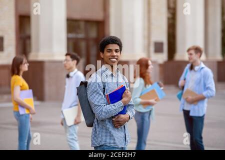 Happy African Student Posiert Mit Büchern Stehen In Der Nähe Der Universität Im Freien Stockfoto