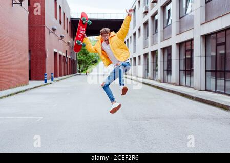 Glücklich und aufgeregt Teenager springen mit Skateboard Stockfoto