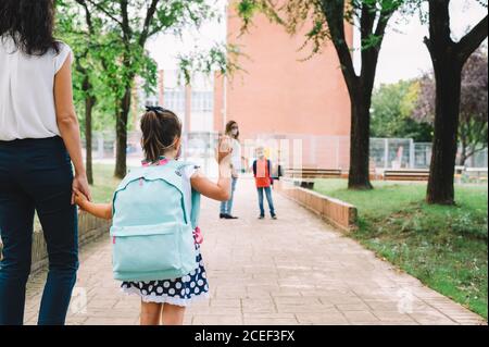 Ein Mädchen trifft einen anderen Jungen, als sie wieder zu kommt Schule nach der Pandemie Stockfoto