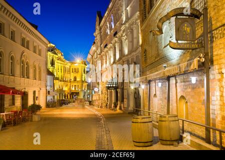 Nachtansicht der beleuchteten Ausros Vartu Straße in der Altstadt von Vilnius, Litauen. Medininkai Restaurant und Royale Hotel auf der rechten Seite. Litauisch N Stockfoto