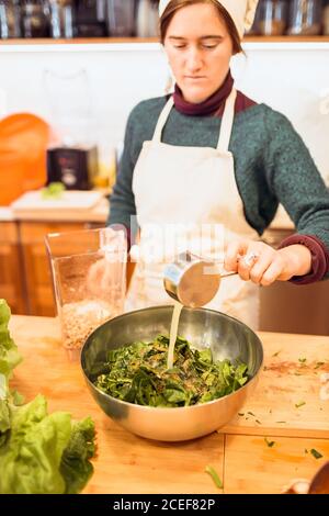 Koch gießt Sauce zu Salat Stockfoto