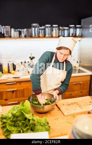 Koch gießt Sauce zu Salat Stockfoto