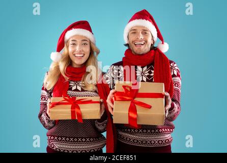 Weihnachtseinkäufe. Portrait von glücklichen Paar mit Weihnachtsgeschenke auf blauem Hintergrund Stockfoto