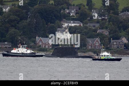 Ein Polizeipatrouillenboot fährt auf einem Segelboot, während eines der sieben nuklearbetriebenen Angriffsunterseeboote der Royal Navy am Eingang zum Holy Loch und Loch Long in der Nähe von Kilcreggan in Argyll und Bute durch das Wasser fährt. Stockfoto