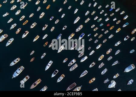 Malerische Luftaufnahme von bunten kleinen Booten und Yachten segeln Auf Veranstaltung von tiefem dunklen Wasser umgeben Stockfoto