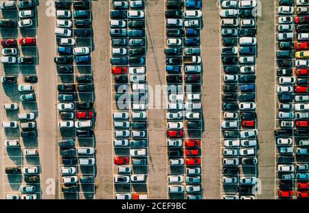 Luftaufnahme der bunten schönen Autos ordentlich in Lot geparkt Auf altem Asphalt an sonnigen Sommertagen Stockfoto