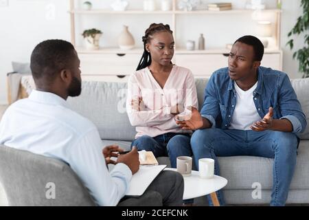 Heiratstherapie-Sitzung. Schwarzes Paar im Gespräch mit Familienberater über Beziehungsprobleme Stockfoto