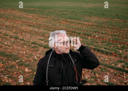 Eleganter Seniorchef in Sonnenbrille in der Natur Stockfoto