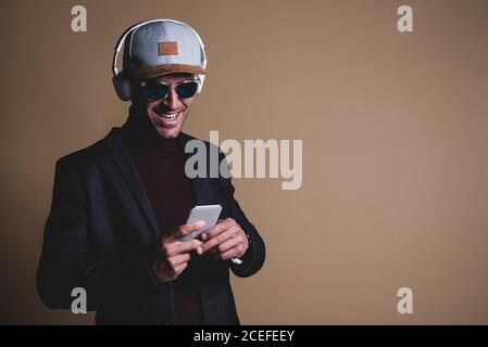 Junger Geschäftsmann in einem Studio auf einem Handy Stockfoto