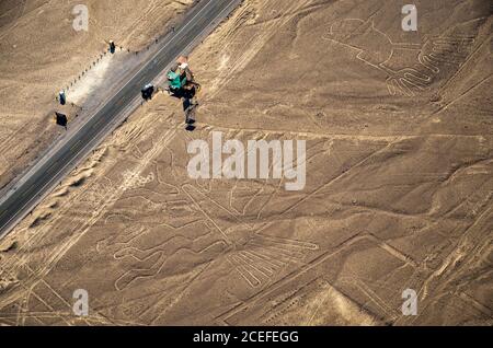 Luftaufnahme der Baum- und Nazca-Linien und der panamerikanischen Autobahn in Peru. Fahrzeug parkt am Aussichtsturm neben mysteriösen Linien. Stockfoto