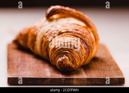 Nahaufnahme von köstlichen frisch gebackenen goldenen Croissants mit goldener Kruste auf Holzbrett. Stockfoto