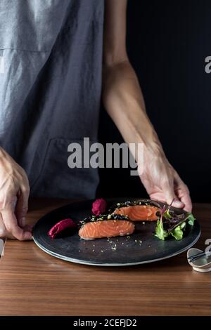 Frau bereitet leckere kandierte Lachsfilets zu Stockfoto