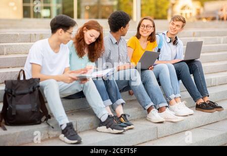 High-School-Studenten Tun Hausarbeit Zusammen Sitzen Auf Stufen Außerhalb Stockfoto