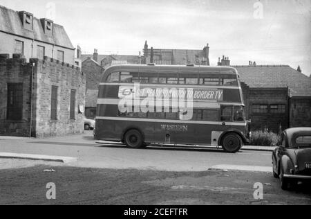 Ein routemaster-Bus hielt in einer Seitenstraße, um dem Fahrer eine Pause zu ermöglichen, trägt eine Werbung für Border Television im Jahr 1950s. Der Fahrer kann auf der Rückseite eine Pause machen zu sehen. Stockfoto