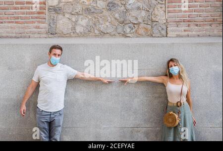 Mann und Frau tragen Gesichtsmaske stehen 6 Fuß voneinander entfernt halten soziale Distanzierung Vermeidung von körperlichem Kontakt, Infektion und die Ausbreitung von coron Stockfoto