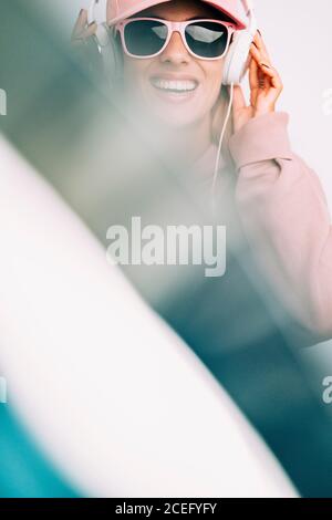Frau in Sonnenbrille, die Musik hört Stockfoto
