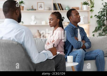 Beziehungskrise. Beleidigt schwarzen Mann und Frau sitzen im Büro des Familienberaters Stockfoto