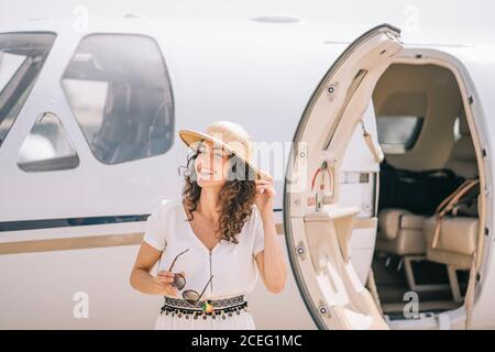 Hübsche Frau senkt ein Außenflugzeug. Stockfoto