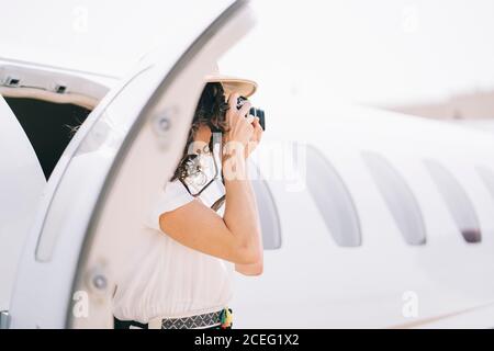 Pretty Woman senkt ein Flugzeug im Freien und macht Fotos. Stockfoto