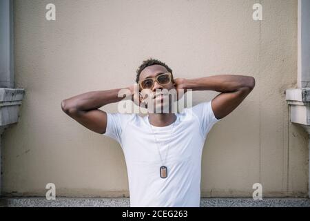 Afrikanischer Mann trägt weißes Hemd und Sonnenbrille posiert. Stockfoto