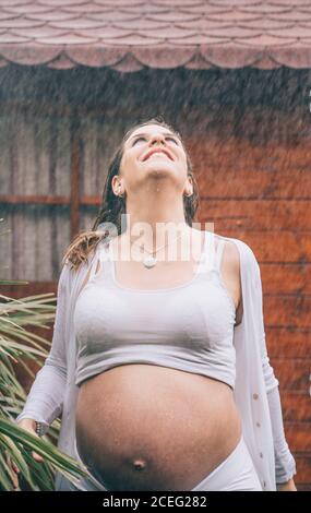 Schöne Schwangerin posiert im Regen. Stockfoto