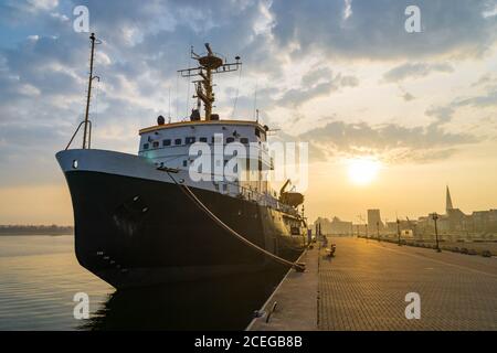 Schiff am Hafen in Rostock bei Sonnenuntergang Stockfoto