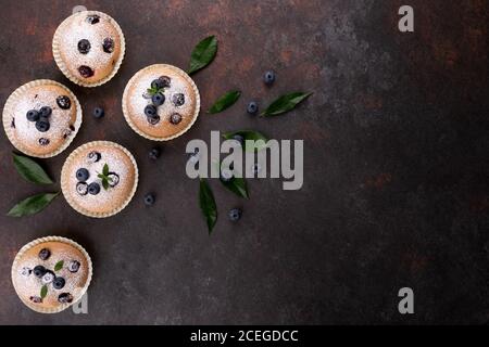 Heidelbeer Muffins auf braunem Holzhintergrund flach mit Kopie legen Platz Stockfoto