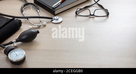 Blutdruckmessgeräte, Hypertonie-Kontrolle. Medizinisches Stethoskop und Sphygmomanometer auf Arztpraxis Schreibtisch, Nahaufnahme. Stockfoto