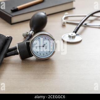 Blutdruckmessgeräte, Hypertonie-Kontrolle. Medizinisches Stethoskop und Sphygmomanometer auf Arztpraxis Schreibtisch, Nahaufnahme. Stockfoto