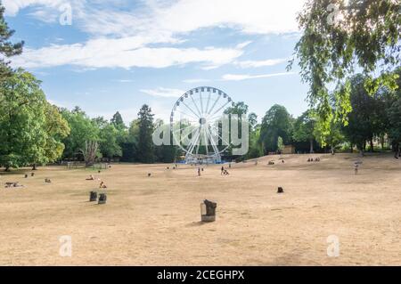 Riesenrad im Zentralpark (Pescatore Park) In Luxemburg auf einem trockenen COVID Sommer mit sehr wenig Menschen und ausgetrocknete Gras Stockfoto