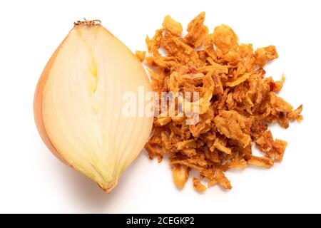 Haufen knusprig gebratene Zwiebeln neben der Hälfte der frischen Zwiebel auf weiß isoliert. Draufsicht. Stockfoto