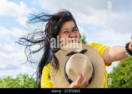 Eine Asiatin mittleren Alters, Mitte 50, mit Strohhut. Stockfoto