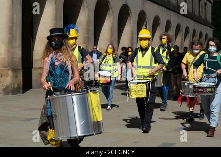 Extinction Rebellion Protest, St. Peter's Square Manchester, Großbritannien. Demonstranten, die mit Trommeln vor der Rathauserweiterung laufen. Stockfoto