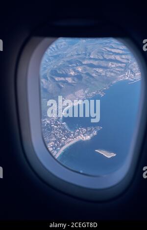 Blick auf Wolken und Berge aus dem Flugzeugfenster Stockfoto